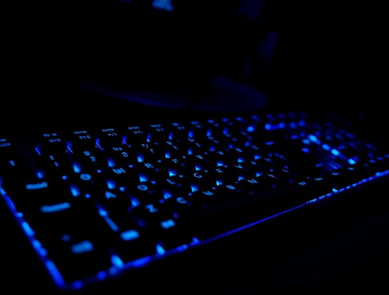 Dark gaming keyboard with blue backlighting, suggesting a professional gaming setup